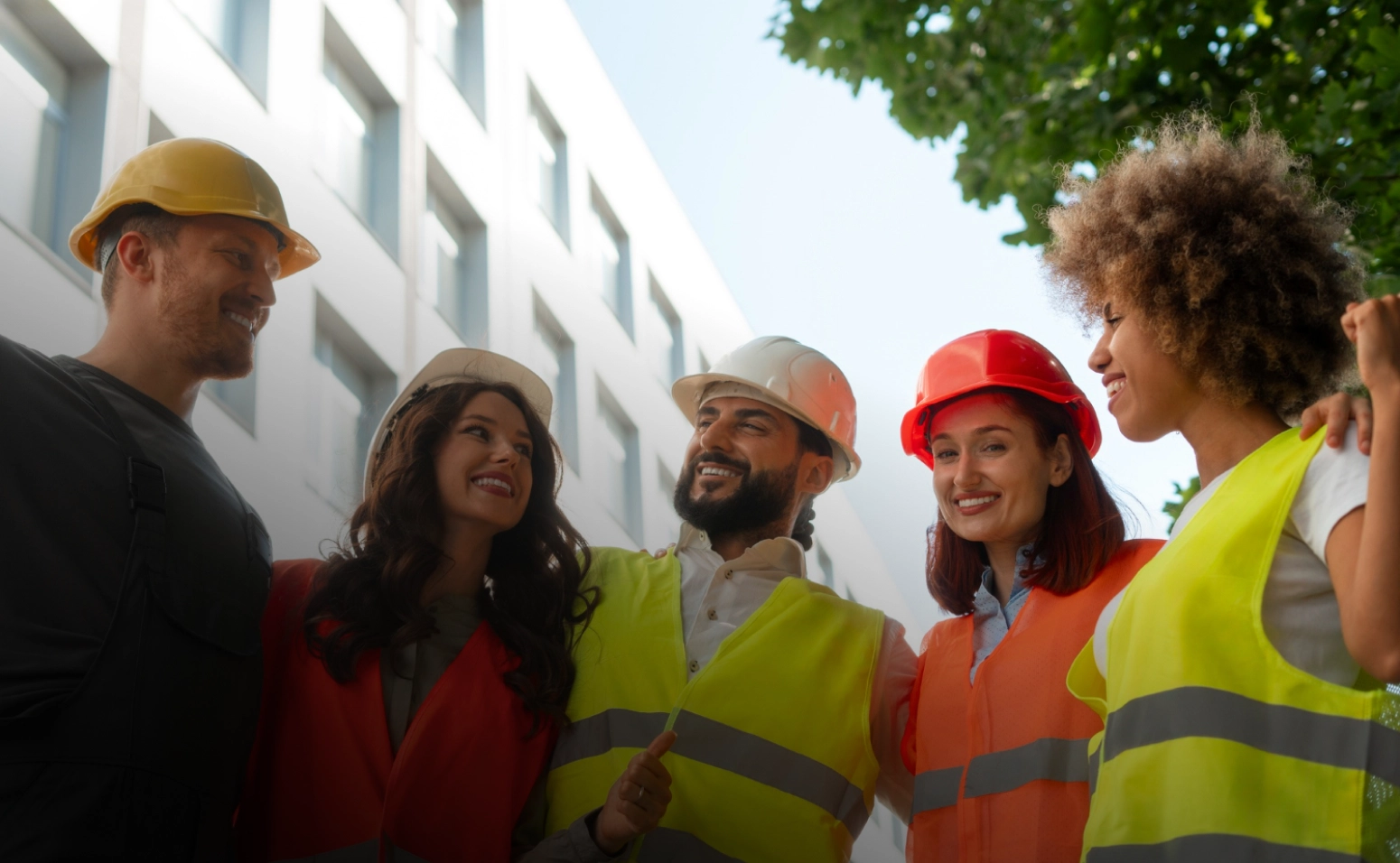 A smiling crew in high-visibility vests posing outside a job site