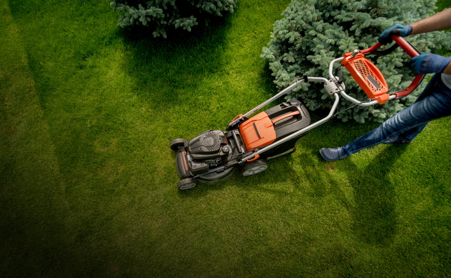 A mower cutting a wide commercial lawn, shot from above
